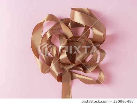 satin ribbon color Mocha Mousse on light pink background satin ribbon color Mocha Mousse on light pink background 120993493