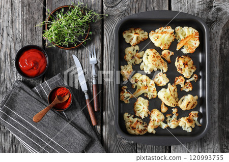oven baked cauliflower florets in a baking tray oven baked cauliflower florets in a baking tray 120993755