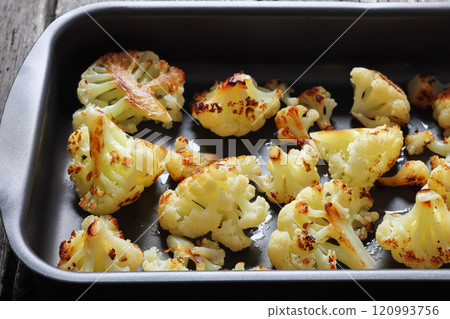 oven baked cauliflower florets in a baking tray oven baked cauliflower florets in a baking tray 120993756