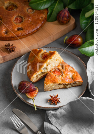 Fig pie. A piece of delicious sponge cake on a plate on a dark background Fig pie. A piece of delicious sponge cake on a plate on a dark background 120994155