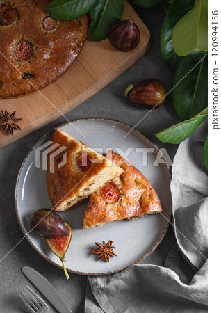 Fig pie. A piece of delicious sponge cake on a plate on a dark background Fig pie. A piece of delicious sponge cake on a plate on a dark background 120994156