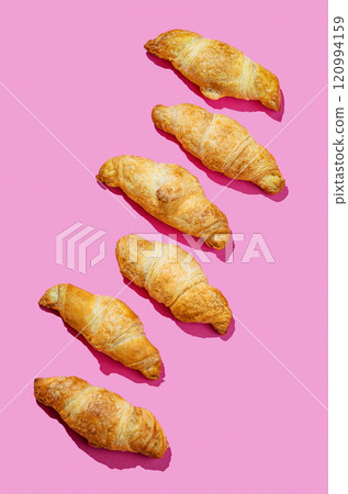 Flat lay of  fresh croissants on pink background with shadow. Creative layout 120994159
