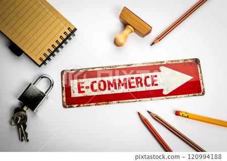 E-COMMERCE Concept. Red direction arrow with text on white office desk E-COMMERCE Concept. Red direction arrow with text on white office desk 120994188