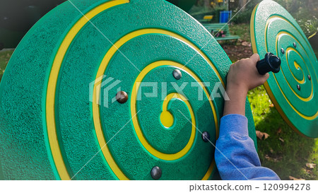 Large children's sensory toys on the playground and the child who plays with them. Concept of development of fine motor skills, Montesori for children outdoors 120994278