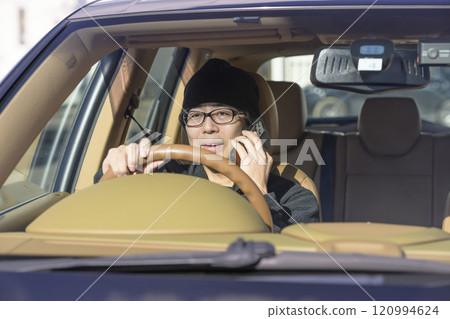 Image of a man driving while talking on his smartphone 120994624