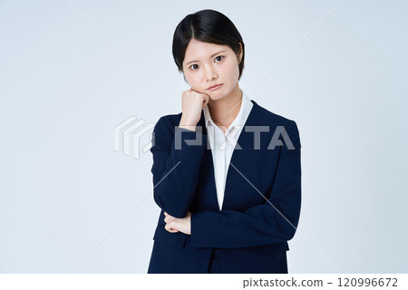 A woman in a suit with a worried expression 120996672