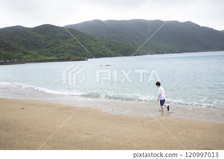 男孩在沙灘上散步 120997013