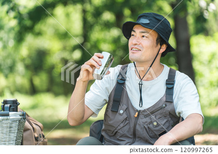 一名男子在露營地享受露營和豪華露營（飲用水、咖啡和啤酒） 120997265