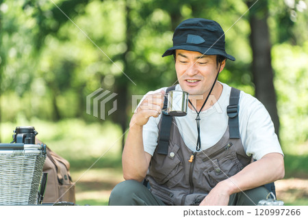 A man enjoying camping glamping at a campsite (drinking water, coffee and beer) A man enjoying camping glamping at a campsite (drinking water, coffee and beer) 120997266