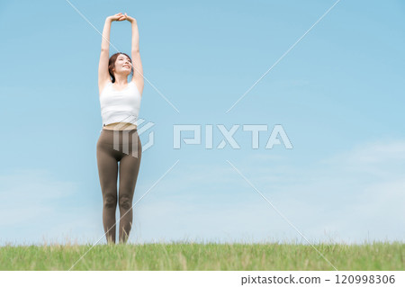 穿著瑜珈服的女人在藍天下伸展(運動、深呼吸、日光浴、提神、緩解壓力) 穿著瑜珈服的女人在藍天下伸展(運動、深呼吸、日光浴、提神、緩解壓力) 120998306
