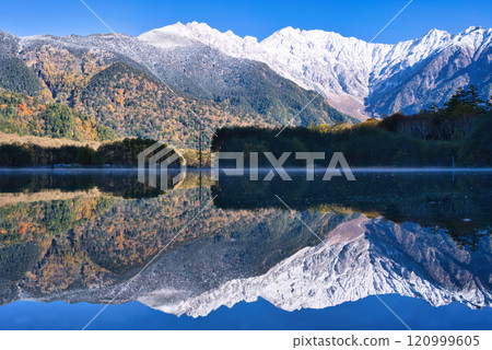 Snow-capped Hotaka mountain range and autumn leaves reflected in Taisho Pond Snow-capped Hotaka mountain range and autumn leaves reflected in Taisho Pond 120999605