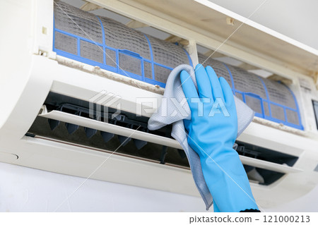 Hands cleaning the air conditioner 121000213