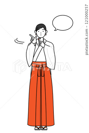 A shrine maiden in a white robe and scarlet hakama operating a smartphone 121000257