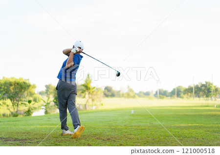 Asian male amateur golfer is enjoy playing golf at golf course in morning, he is showing his beautiful swing during tee off. Man playing golf. Asian male amateur golfer is enjoy playing golf at golf course in morning, he is showing his beautiful swing during tee off. Man playing golf. 121000518