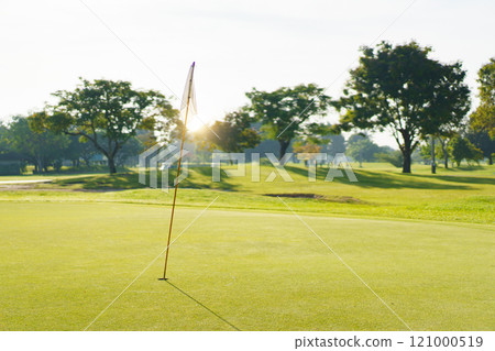 Landscape of putting green in golf course. Asian male amateur golfer is enjoy playing golf at golf course in morning, he is showing his beautiful swing during tee off. Man playing golf. Landscape of putting green in golf course. Asian male amateur golfer is enjoy playing golf at golf course in morning, he is showing his beautiful swing during tee off. Man playing golf. 121000519