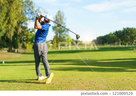 Asian male amateur golfer is enjoy playing golf at golf course in morning, he is showing his beautiful swing during tee off. Man playing golf. 121000520