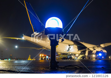 Taxiway, side row lights on the background of a large passenger aircraft at the night airport apron Taxiway, side row lights on the background of a large passenger aircraft at the night airport apron 121001126