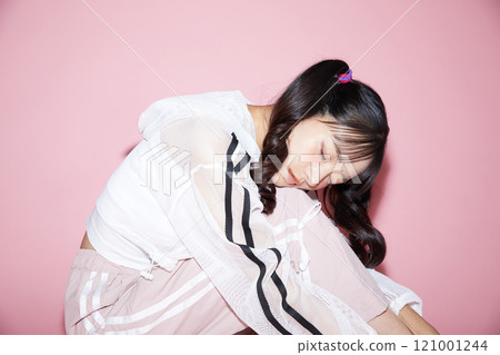 Cute portrait of a young woman in sporty clothes photographed against a pink background Cute portrait of a young woman in sporty clothes photographed against a pink background 121001244