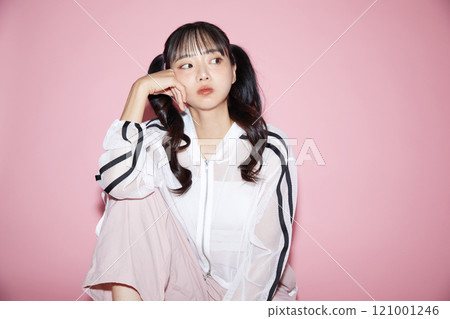 Cute portrait of a young woman in sporty clothes photographed against a pink background Cute portrait of a young woman in sporty clothes photographed against a pink background 121001246
