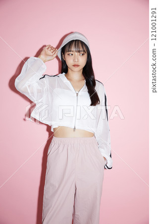 粉紅色背景下拍攝的一位穿著運動服的年輕女子的可愛肖像 粉紅色背景下拍攝的一位穿著運動服的年輕女子的可愛肖像 121001291