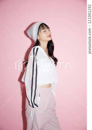 粉紅色背景下拍攝的一位穿著運動服的年輕女子的可愛肖像 粉紅色背景下拍攝的一位穿著運動服的年輕女子的可愛肖像 121001292