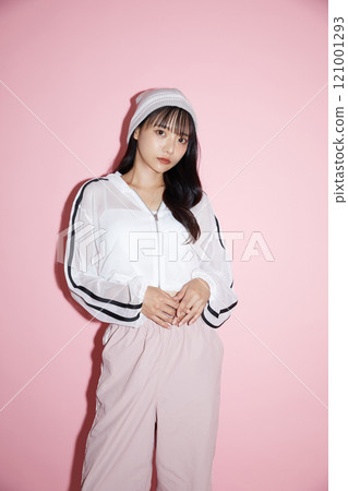 粉紅色背景下拍攝的一位穿著運動服的年輕女子的可愛肖像 粉紅色背景下拍攝的一位穿著運動服的年輕女子的可愛肖像 121001293