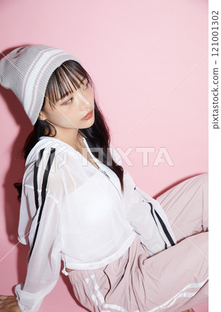Cute portrait of a young woman in sporty clothes photographed against a pink background Cute portrait of a young woman in sporty clothes photographed against a pink background 121001302