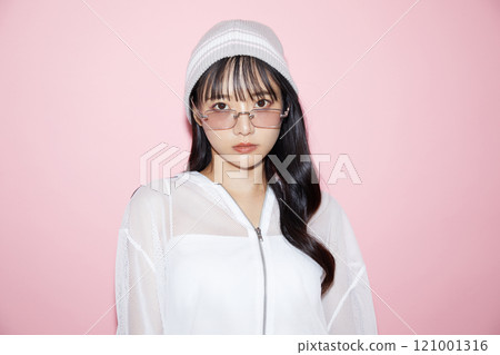 Cute portrait of a young woman in sporty clothes photographed against a pink background Cute portrait of a young woman in sporty clothes photographed against a pink background 121001316