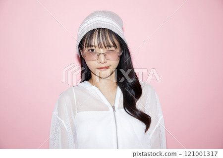 Cute portrait of a young woman in sporty clothes photographed against a pink background Cute portrait of a young woman in sporty clothes photographed against a pink background 121001317
