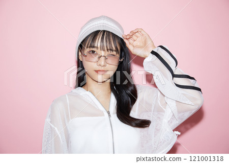 粉紅色背景下拍攝的一位穿著運動服的年輕女子的可愛肖像 粉紅色背景下拍攝的一位穿著運動服的年輕女子的可愛肖像 121001318