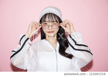 粉紅色背景下拍攝的一位穿著運動服的年輕女子的可愛肖像 121001319