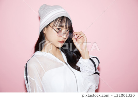 粉紅色背景下拍攝的一位穿著運動服的年輕女子的可愛肖像 121001320