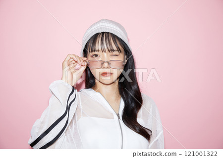 粉紅色背景下拍攝的一位穿著運動服的年輕女子的可愛肖像 121001322