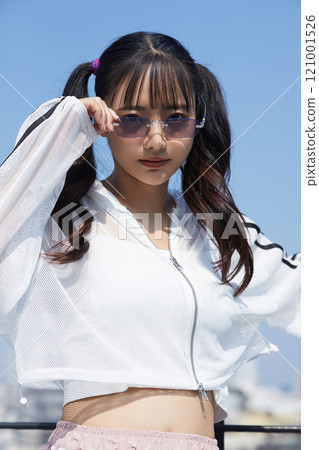 Casual and fashionable portrait of a young woman taken outdoors 121001526