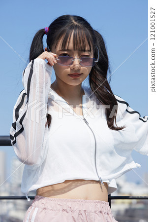 Casual and fashionable portrait of a young woman taken outdoors 121001527