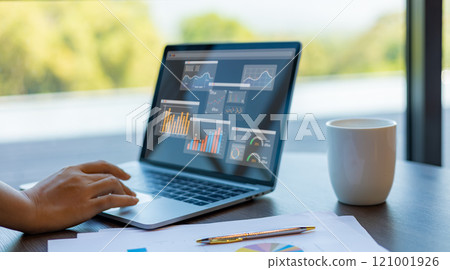 Business woman show laptop to analyze business and manage corporate data, Business analytics with charts, metrics and KPIs to improve organizational performance, Marketing and financial strategy. 121001926