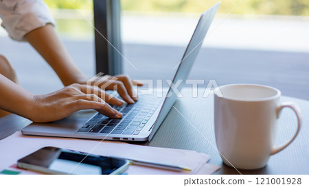 Female hands typing on laptop computer keyboard on wood desk at office, Technology, Business concept. Business woman analyze the graph of the company performance to create profits and growth. 121001928