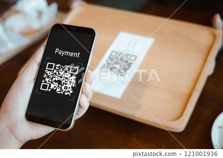 Hand using mobile phone application to scan QR code, Hands holding mobile phone, Qr code payment or cashless technology concept, Coffee shop accepting digital pay without money, Meaningless QR code. Hand using mobile phone application to scan QR code, Hands holding mobile phone, Qr code payment or cashless technology concept, Coffee shop accepting digital pay without money, Meaningless QR code. 121001936