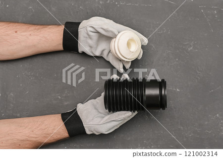 The shock absorber cover and the shock absorber bump are in the hands of a mechanic. auto parts concept  121002314