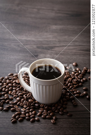 Hot coffee and coffee beans on the table Hot coffee and coffee beans on the table 121002877