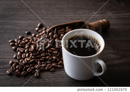 Hot coffee and coffee beans on the table Hot coffee and coffee beans on the table 121002878