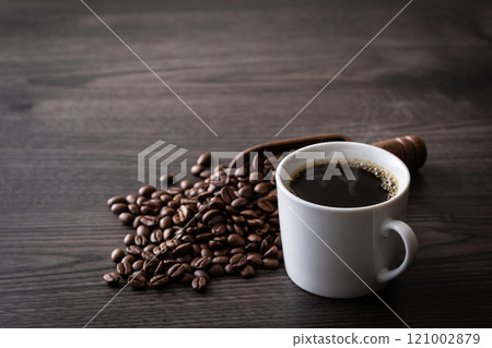 Hot coffee and coffee beans on the table Hot coffee and coffee beans on the table 121002879