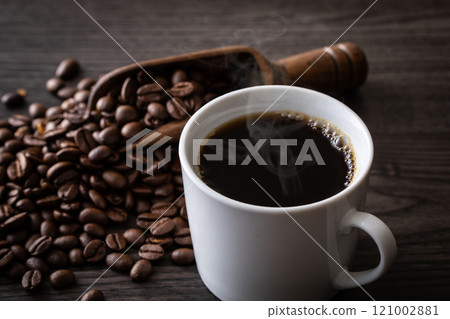 Hot coffee and coffee beans on the table 121002881
