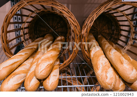 Wicker basket filled with baguettes Wicker basket filled with baguettes 121002943
