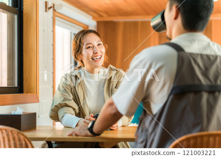 一對夫婦在小屋、小木屋或木屋裡邊喝咖啡邊微笑和交談 一對夫婦在小屋、小木屋或木屋裡邊喝咖啡邊微笑和交談 121003221