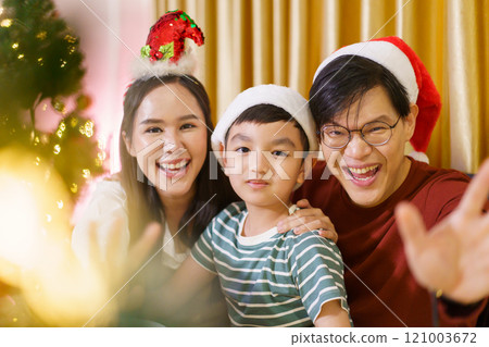 Lovely Asian family mother, father, and son celebrating Christmas and New Year dinner party together. 121003672