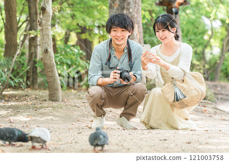 Man and woman taking photos with a single-lens reflex camera on a trip 121003758
