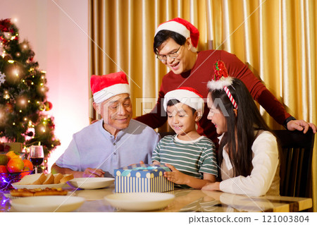 Asian family celebrate Christmas Festival together. Happy cheerful Asian family is celebrating Christmas and New Year dinner party together, a family with mother, father and son.  121003804