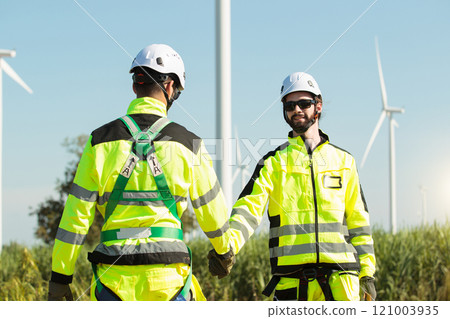 Team of electrical engineer is perform the inspection and maintenance of electric generating windmill turbine. Team of professional electrical engineers in fully safety suit are working and discussing Team of electrical engineer is perform the inspection and maintenance of electric generating windmill turbine. Team of professional electrical engineers in fully safety suit are working and discussing 121003935