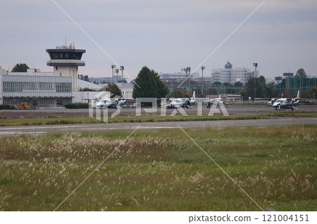 (Chofu Airport, Tokyo) A small passenger plane with passengers boarding outside the passenger terminal 121004151